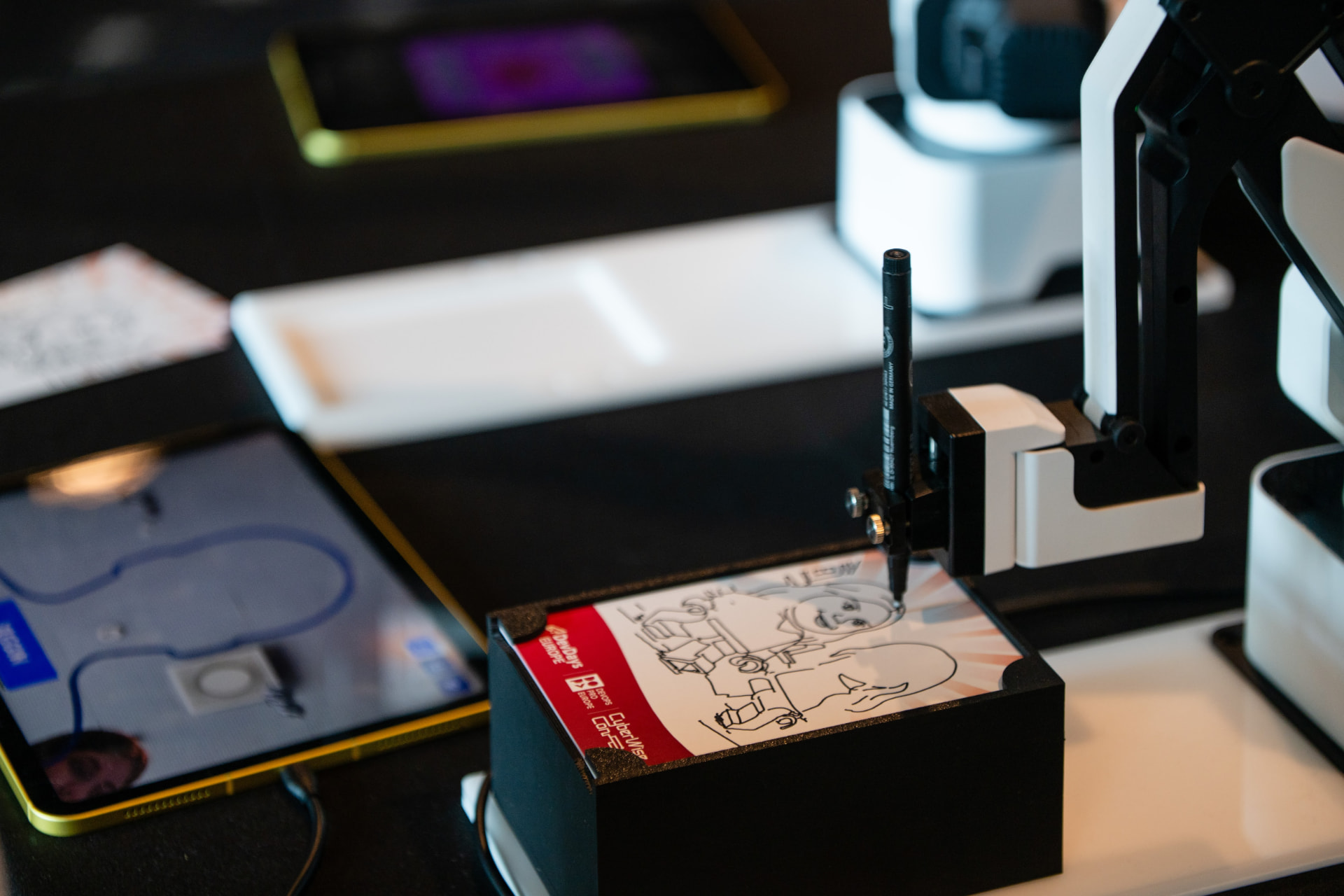 Close-up of the robotic pen finishing a branded portrait card